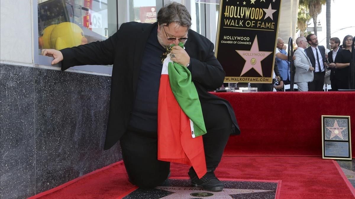 El cineasta mexicano Guillermo del Toro besa una bandera mexicana arrodillado en su recién descubierta estrella del Paseo de la Fama de Hollywood, en Los Ángeles (California, EEUU), este martes. El cineasta mexicano Guillermo del Toro besa una bandera mexicana arrodillado en su recién descubierta estrella del Paseo de la Fama de Hollywood, en Los Ángeles (California, EEUU), este martes.