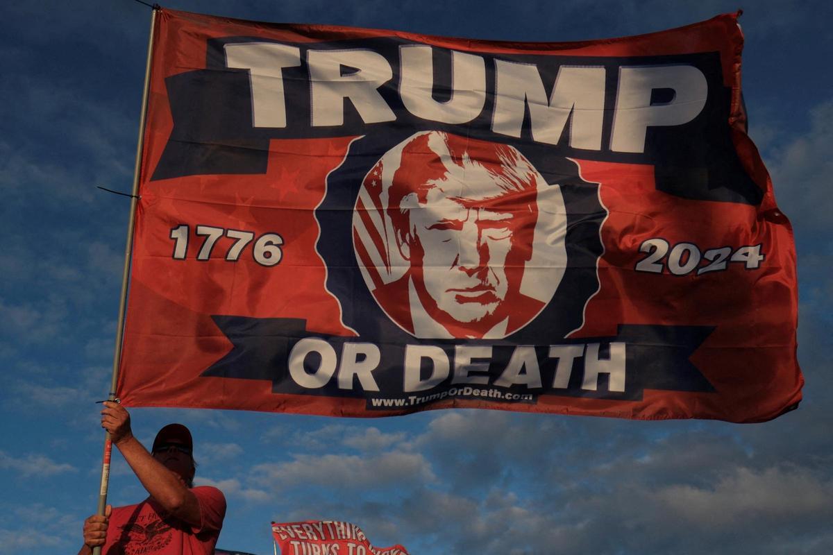 Un seguidor de Trump ondea una bandera con el lema ’Trump o muerte’ en el exterior del complejo de Mar-a-Lago, esta semana en Florida. Un seguidor de Trump ondea una bandera con el lema ’Trump o muerte’ en el exterior del complejo de Mar-a-Lago, esta semana en Florida.