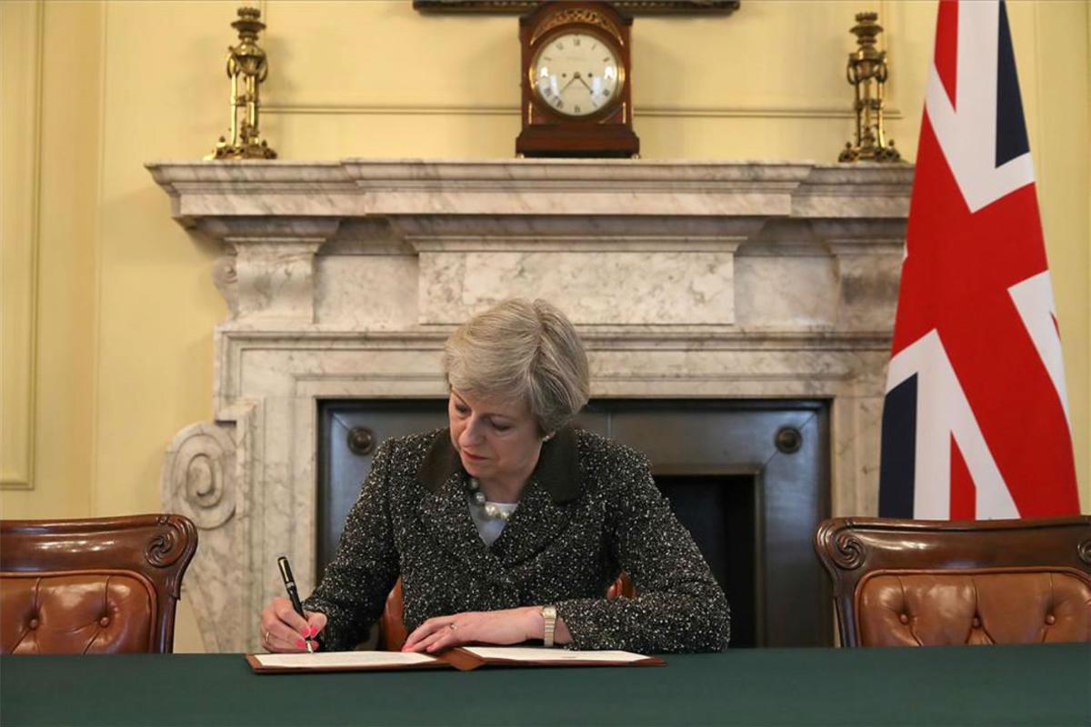 La primera ministra británica, Theresa May, firma la carta con la que arranca el ’brexit’.