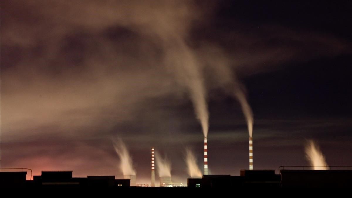 Chimeneas de una planta de energia de carbon emiten humo durante la noche en Changchun en China Chimeneas de una planta de energia de carbon emiten humo durante la noche en Changchun en China