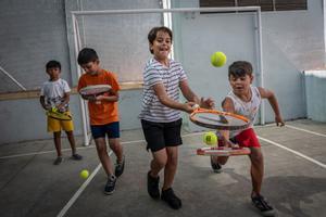 Un grupo de niños del centro socioeducativo Poble-Sec de la Fundació Pere Tarrés, en una clase de tenis.
