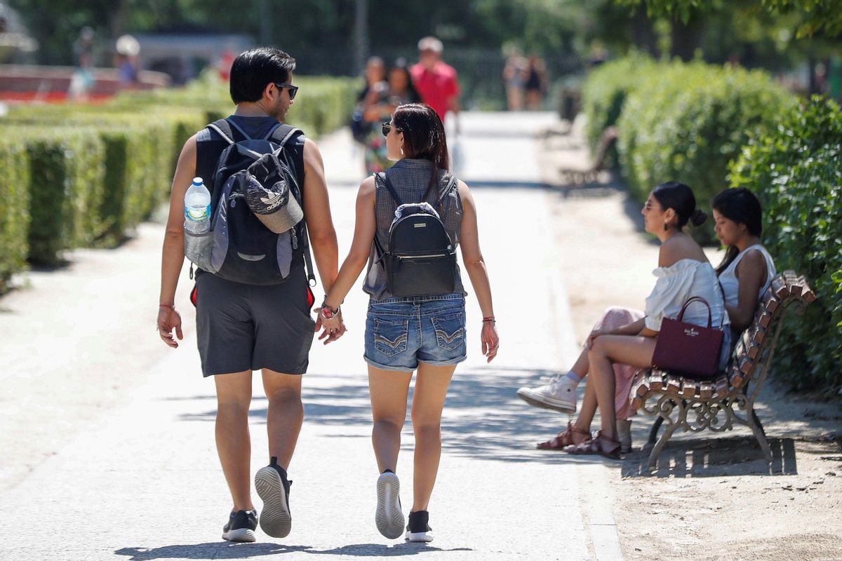 Dos jóvenes pasean por un parque de Madrid. Dos jóvenes pasean por un parque de Madrid.