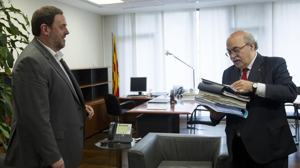 Andreu Mas-Colell (derecha) entrega documentación a su sucesor al frente de la Conselleria d’Economia, Oriol Junqueras, el 14 de enero del 2016, día del traspaso de carteras.