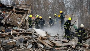 Trabajadores de rescate trabajan en una casa residencial dañada durante un ataque ruso con misiles en Kiev.