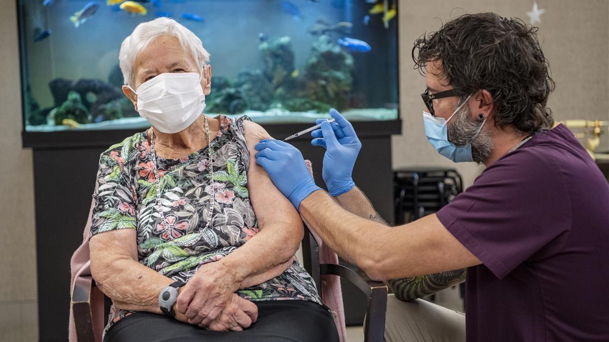 Una anciana, de 90 años, recibe su primera dosis de la vacuna Pfizer-BioNTech.
