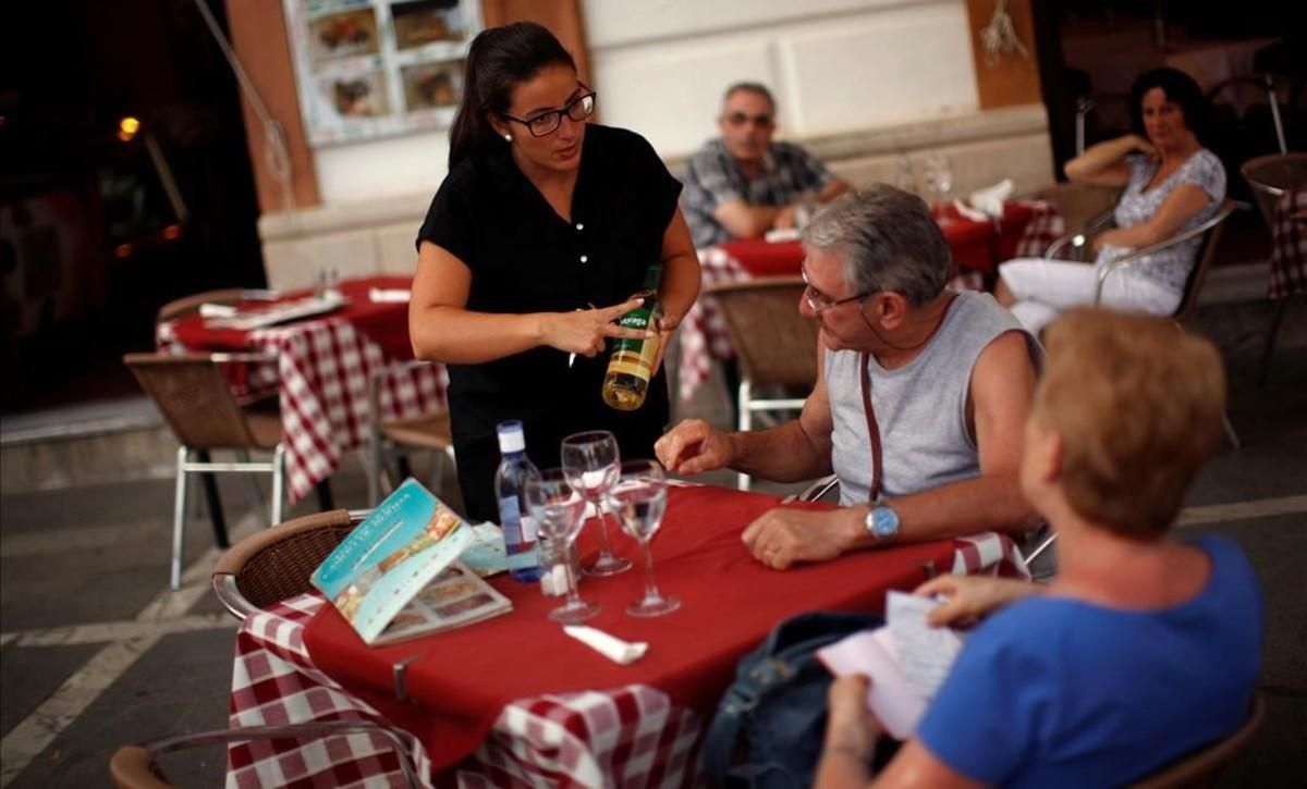 Una camarera con contrato temporal sirve vino a unos clientes en el Casino de Ronda. Una camarera con contrato temporal sirve vino a unos clientes en el Casino de Ronda.