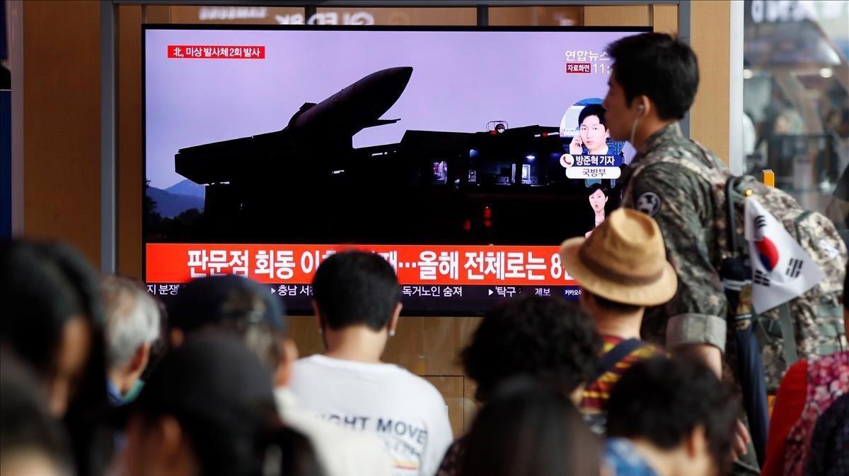 Un grupo de surcoreanos ven este viernes  en la pantalla de un comercio  las ultimas noticias sobre los proyectiles de corto alcance que ha lanzado Corea del Norte desde su costa oriental.