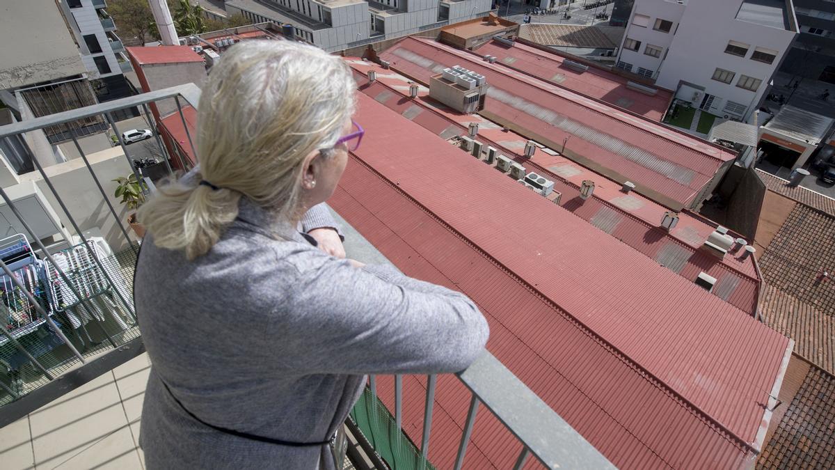 Montse Parera ante el techo de amianto de la nave que tiene frente a su piso en la calle de Pallars