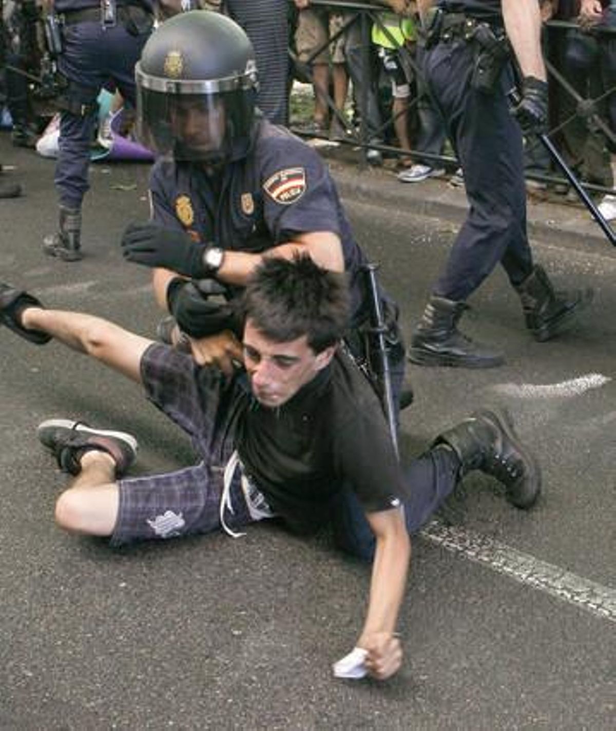 Un policía forcejea con un miembro del colectivo de indignados que se habían concentrado en las proximidades del Congreso de los Diputados. Un policía forcejea con un miembro del colectivo de indignados que se habían concentrado en las proximidades del Congreso de los Diputados.