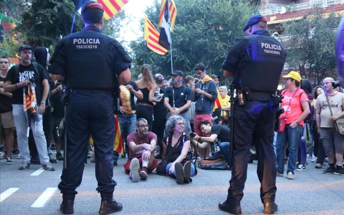 Dos agents dels Mossos d’Esquadra, davant d’un grup de persones d’ideologia independentista concentrades a la caserna de la Guàrdia Civil de Travessera de Gràcia a Barcelona, el 20 de setembre passat. Dos agents dels Mossos d’Esquadra, davant d’un grup de persones d’ideologia independentista concentrades a la caserna de la Guàrdia Civil de Travessera de Gràcia a Barcelona, el 20 de setembre passat.