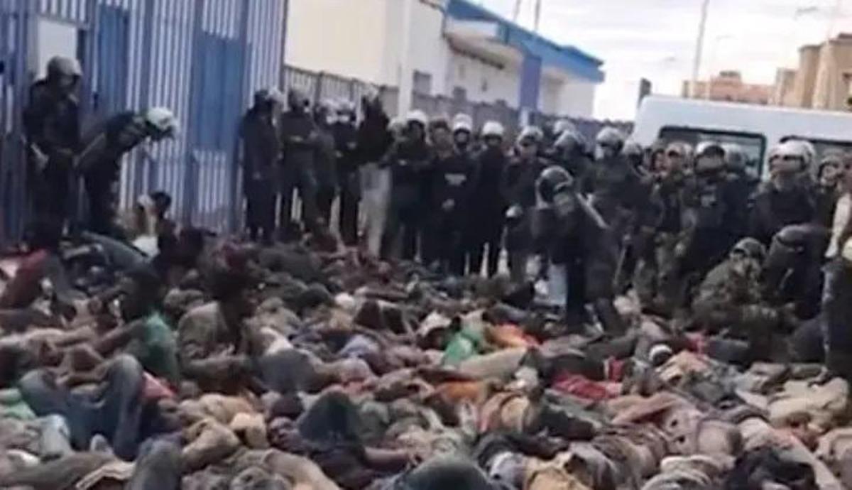 Migrantes tendidos en el suelo ante gendarmes marroquís en el puesto fronterizo del barrio Chino, entre Melilla y Nador, el 24 de junio.