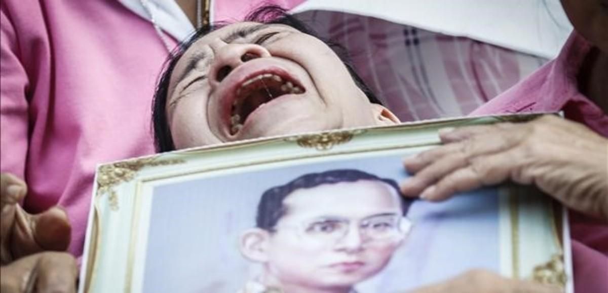 Una mujer llora a las puertas del hospital con la la foto del rey Bhumibol. Una mujer llora a las puertas del hospital con la la foto del rey Bhumibol.
