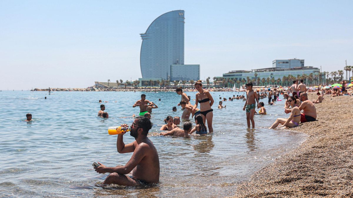 Soportando las altas temperaturas en la playa de la Barceloneta este mediodía Soportando las altas temperaturas en la playa de la Barceloneta este mediodía