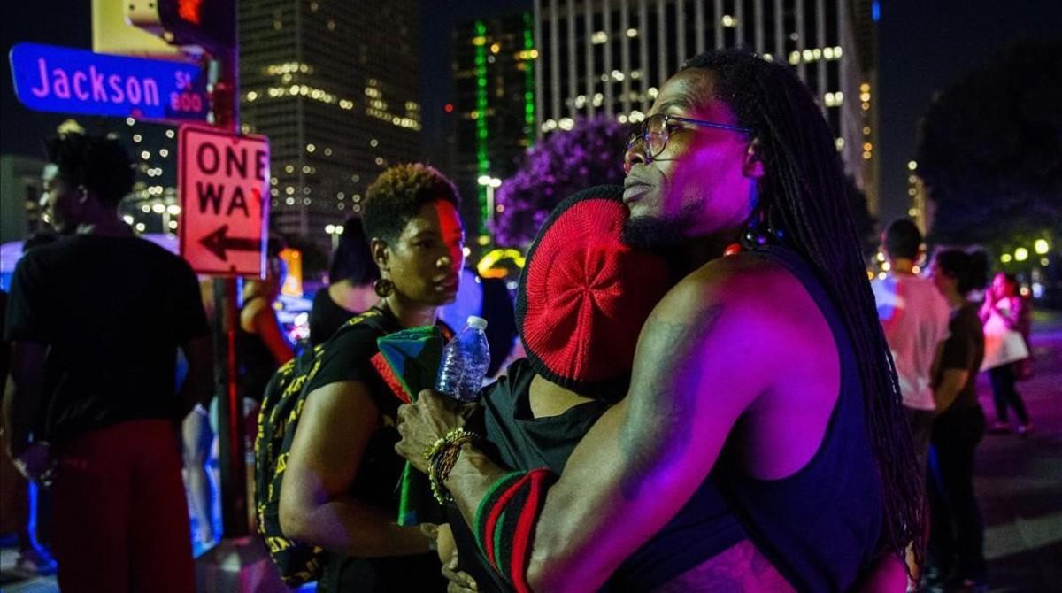 Manifestantes se abrazan tras los disparos durante la protesta en Dallas.