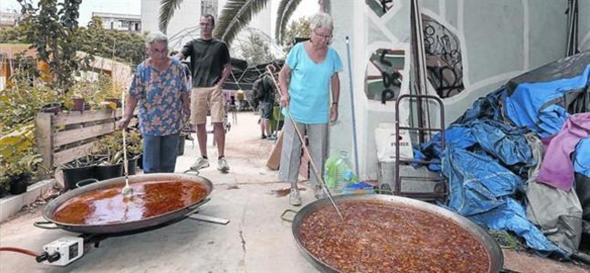 Unas vecinas cocinan dos paellas en el solar de Germanetes, en el Eixample. Unas vecinas cocinan dos paellas en el solar de Germanetes, en el Eixample.