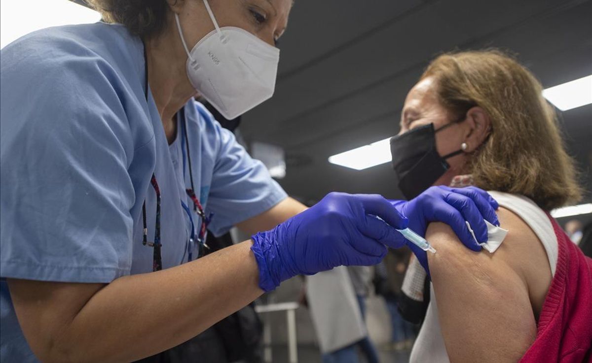 Una trabajadora sanitaria administra la primera dosis de la vacuna AstraZeneca contra el Covid-19 a una persona en el Wizink Center de Madrid. Una trabajadora sanitaria administra la primera dosis de la vacuna AstraZeneca contra el Covid-19 a una persona en el Wizink Center de Madrid.