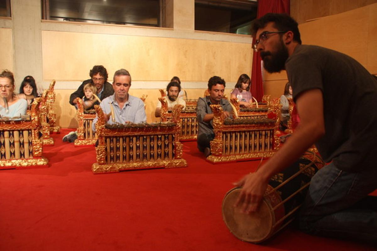 Un músico enseña como se toca el Gamelan a los visitantes del Museu de la Música.