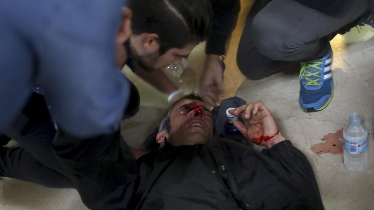 Un manifestante es atendido después de ser golpeado por una bala de goma disparada en la escuela Ramón Llull. 