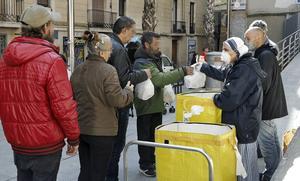 Voluntarios del Comedor Reina de la Paz de las Misioneras de la Caridad reparten alimentos entre personas necesitadas, en el barrio del Raval de Barcelona, el 12 de abril.