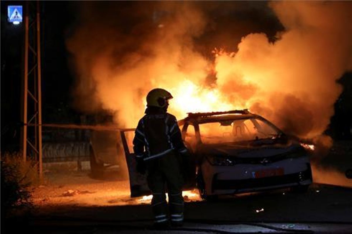 Un coche de la policía incendiado durante los choques en la ciudad de Lod. Un coche de la policía incendiado durante los choques en la ciudad de Lod.