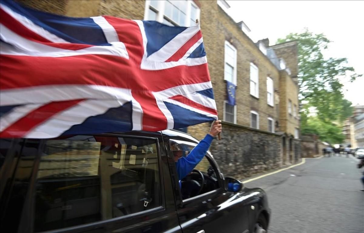 Un motorista con una bandera británica en el centro de Londres. Un motorista con una bandera británica en el centro de Londres.
