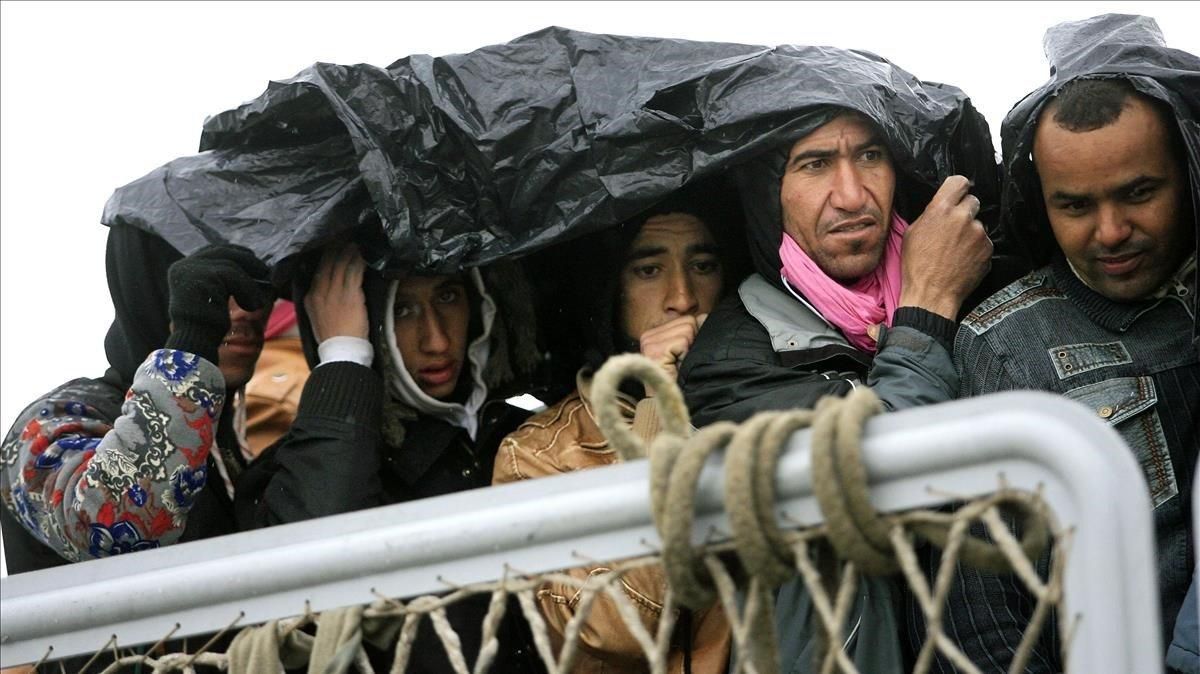 Un grupo de refugiados se protege de la lluvia antes de desembarcar en Porto Empedocle, en el sur de Sicilia. Un grupo de refugiados se protege de la lluvia antes de desembarcar en Porto Empedocle, en el sur de Sicilia.