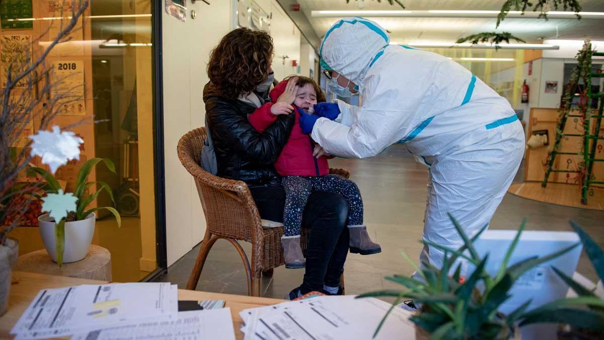 Un técnico sanitario hace una PCR a una niña de 2 años, tras detectarse un caso positivo en su guardería. Un técnico sanitario hace una PCR a una niña de 2 años, tras detectarse un caso positivo en su guardería.