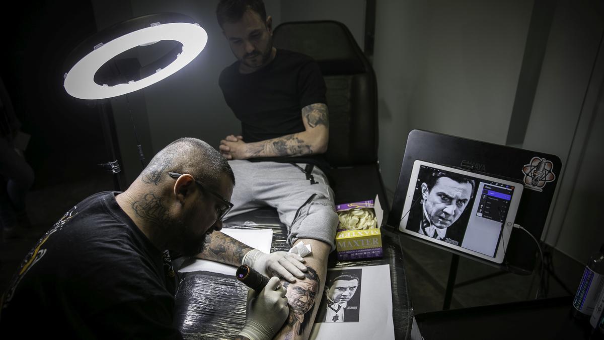 El tatuador Jose Bandera, con un cliente ’reincidente’ desde hace 10 años, en su estudio Soul Hunter Tatto & Piercing de L’Hospitalet de Llobregrat, a principios de mayo.