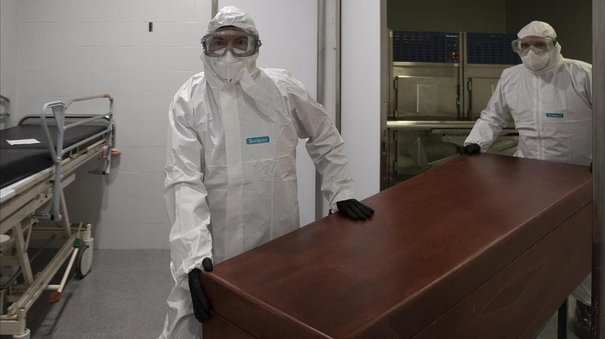 Los funerarios se visten con un EPI para trasladar un difunto fallecido de coronavirus Covid-19 desde la morgue del Hospital de Mataró hasta el tanatorio Los funerarios se visten con un EPI para trasladar un difunto fallecido de coronavirus Covid-19 desde la morgue del Hospital de Mataró hasta el tanatorio
