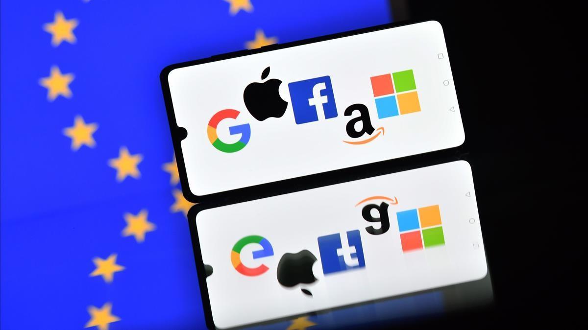Los logotipos de Google, Apple, Facebook, Amazon y Microsoft en un teléfono móvil frente a una bandera de la UE.