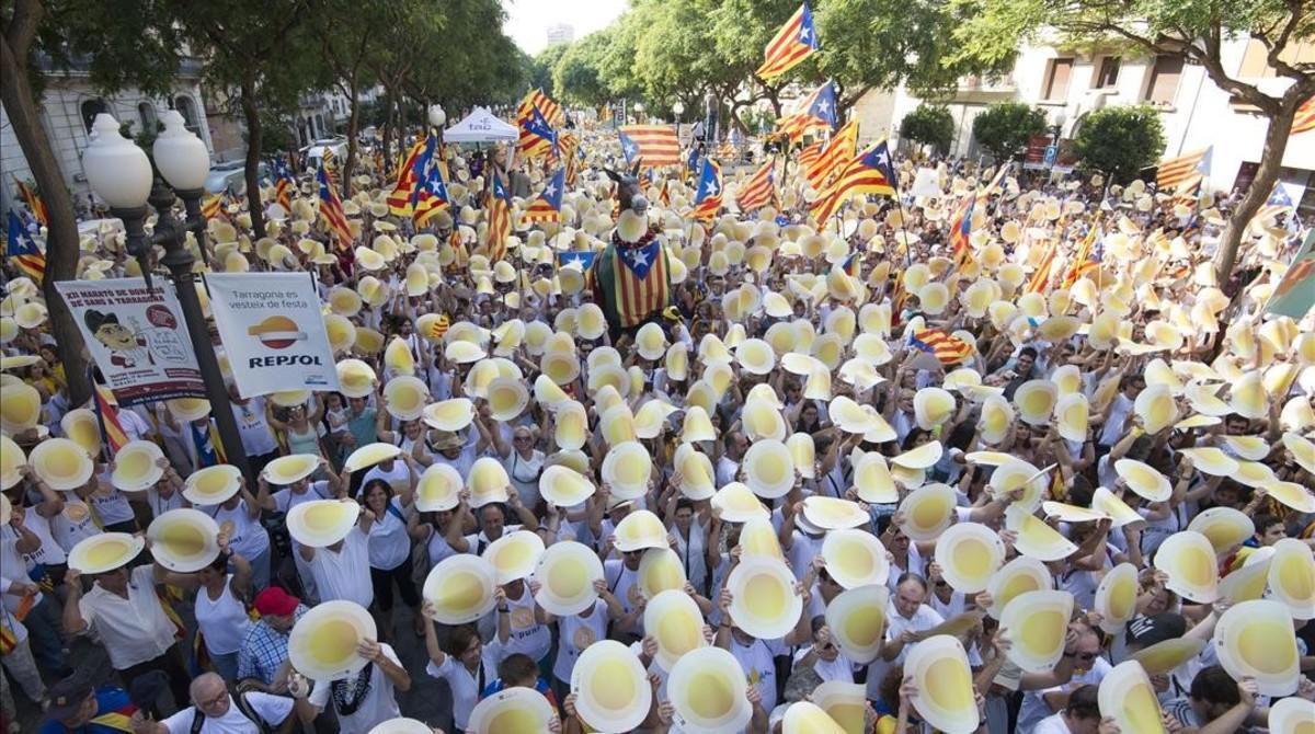 Los manifestantes de Tarragona levantan las cartulinas en forma de punto, este domingo.