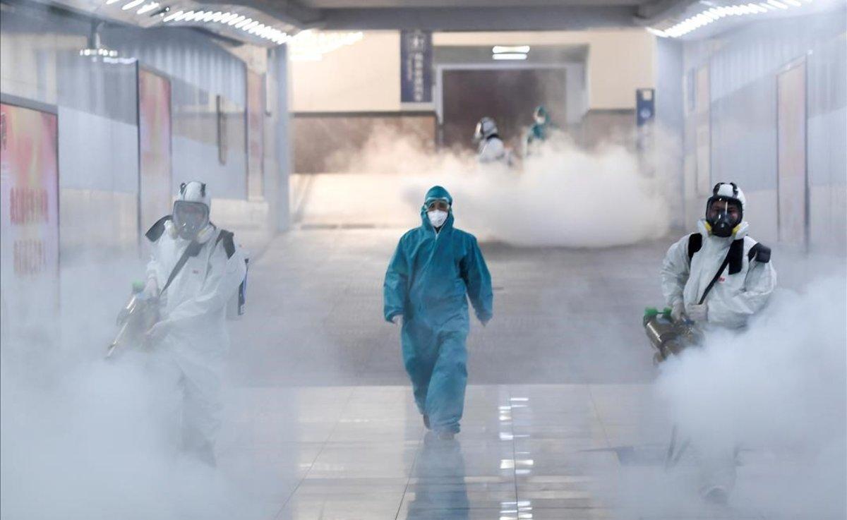 Un grupo de voluntarios desinfectan una estación de tren en Changsha, China, ante posibles contagios de coronavirus.