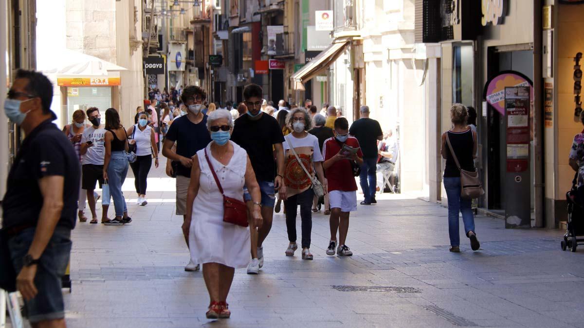 Torra anuncia el confinamiento perimetral de El Segrià (Lleida).  En la foto, ciudadanos paseando por la calle Major de Lleida, poco después de hacerse pública la noticia del confinamiento.