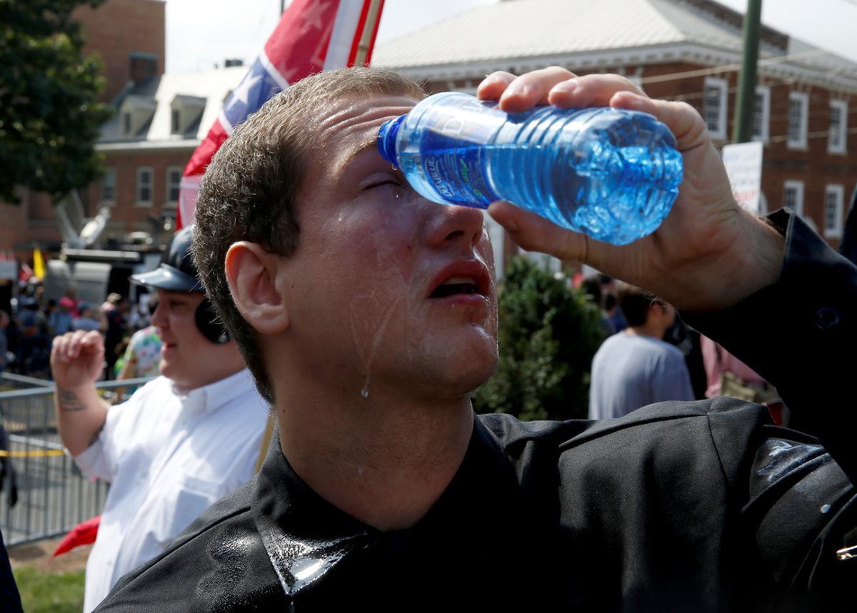 Un manifestante se echa agua en los ojos tras ser rociado con espray pimienta.