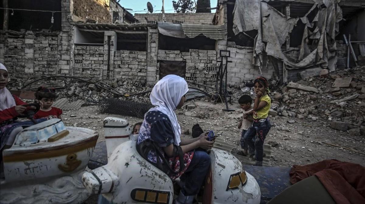 Niños sirios juegan en un carrusel durante el segundo día de la festividad musulmana de Eid Al Adha, en Douma, este martes. Niños sirios juegan en un carrusel durante el segundo día de la festividad musulmana de Eid Al Adha, en Douma, este martes.