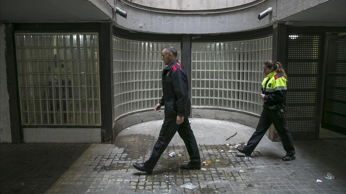 Dos mossos patrullan por lo sbajos de un edificio de La Mina.