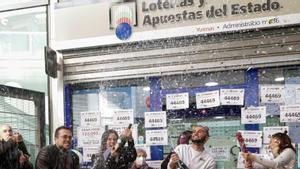 Trabajadores y clientes de una administración de Lotería de Barcelona festejan un premio.