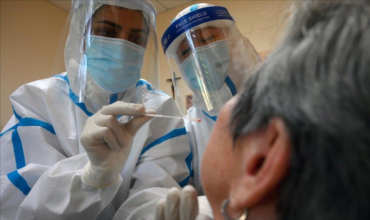 Trabajadores sanitarios hacen un test de coronavirus a uno de los ingresados en la residencia de ancianos Sant Miquel, en Barcelona.