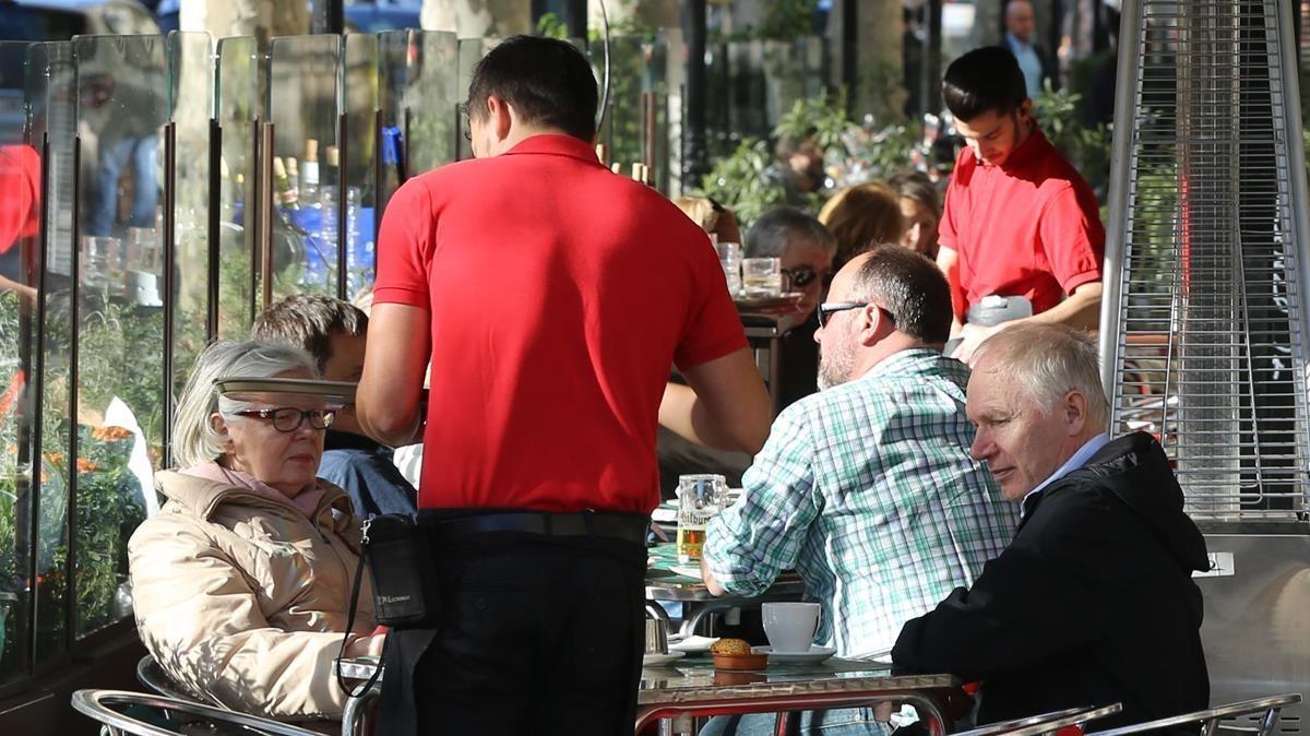 Un camarero en una terraza del paseo de Gràcia.