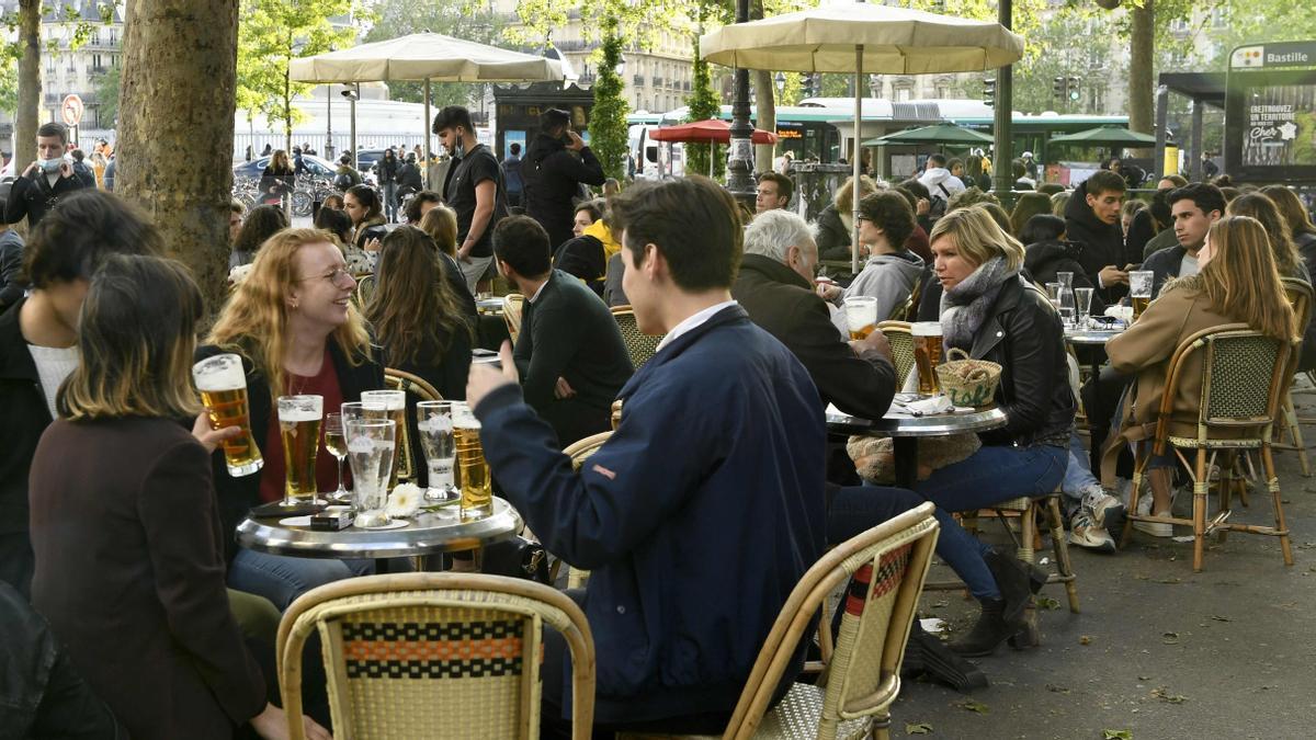 Customers sit on terraces, in Paris, on May 19, 2021 as cafes, restaurants and other businesses re-opened as part of an easing of the nationwide lockdown due to the Covid-19 pandemic. - The French made their way back to cafes and prepared long-awaited visits to cinemas and museums as the country loosened restrictions in a return to semi-normality after over six months of Covid-19 curbs.Cafes and restaurants with terraces or rooftop gardens can now offer outdoor dining, under the second phase of a lockdown-lifting plan that should culminate in a full reopening of the economy on June 30. (Photo by Bertrand GUAY / AFP)