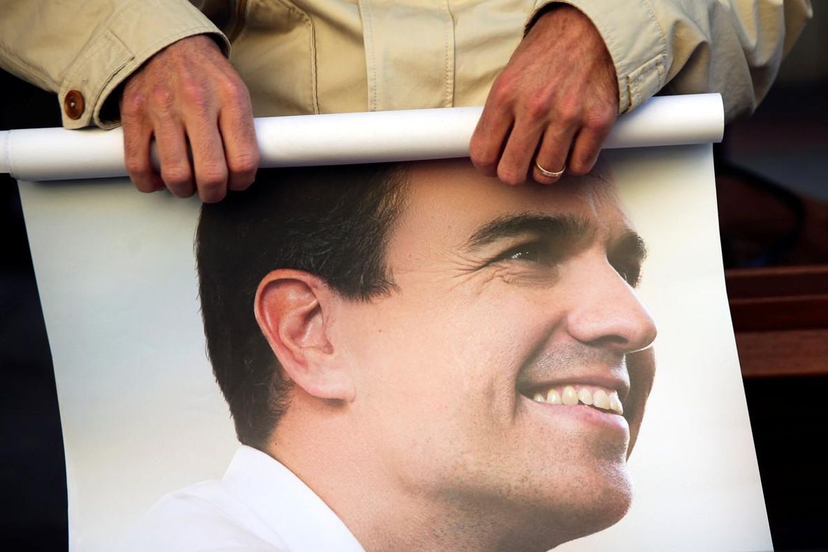 Un seguidor de Sánchez enrolla un cartel del ya exsecretario general del PSOE. Un seguidor de Sánchez enrolla un cartel del ya exsecretario general del PSOE.