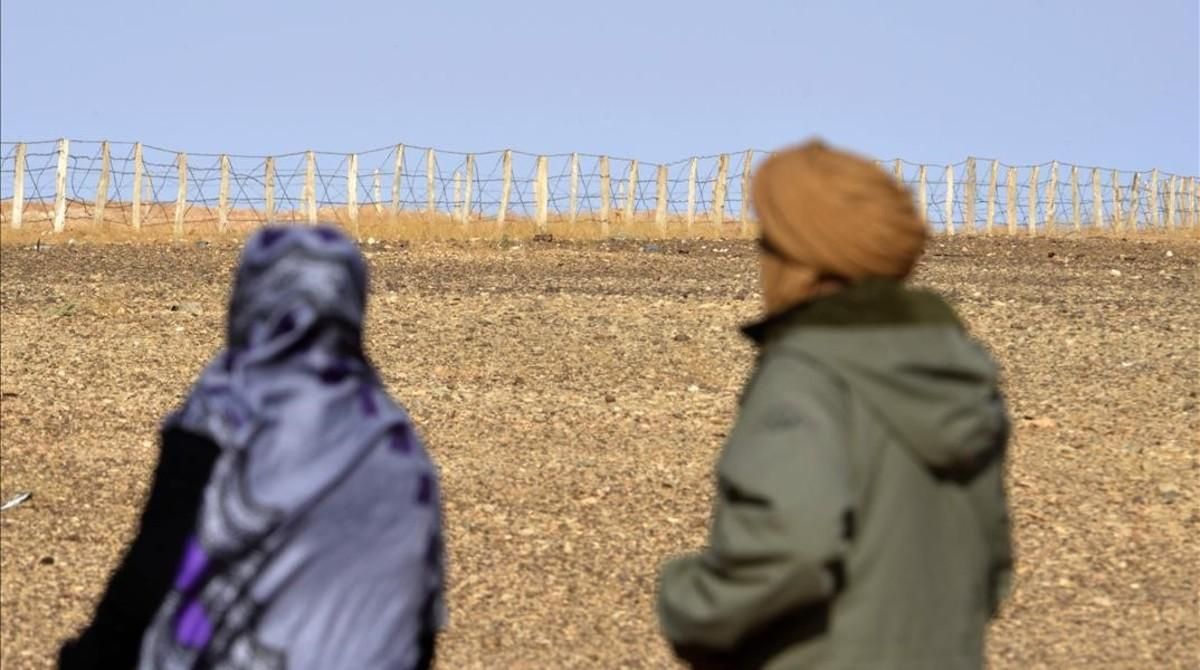 Zghala, una mujer del Sáhara Occidental, mira hacia la valla en el área de Al-Mahbes, mientras acompaña a su hijo de 14 años para mostrarle el muro que separa Marruecos de la zona controlada por el Polisario, el 3 de febrero del 2017. Zghala, una mujer del Sáhara Occidental, mira hacia la valla en el área de Al-Mahbes, mientras acompaña a su hijo de 14 años para mostrarle el muro que separa Marruecos de la zona controlada por el Polisario, el 3 de febrero del 2017.