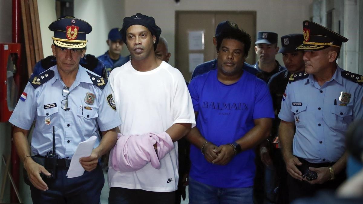 Ronaldinho y su hermano Roberto, esposados y conducidos por la policía a declarar en los juzgados de Asunción. Ronaldinho y su hermano Roberto, esposados y conducidos por la policía a declarar en los juzgados de Asunción.