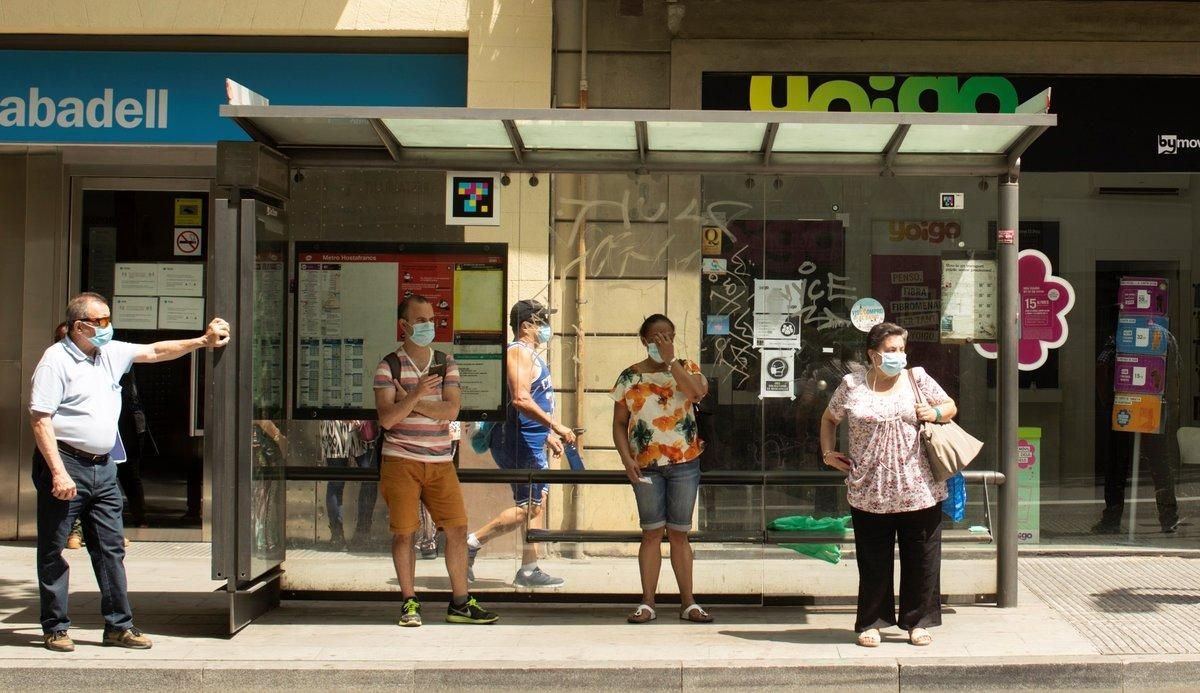 Varias personas esperan el autobús en una parada en Barcelona. Varias personas esperan el autobús en una parada en Barcelona.