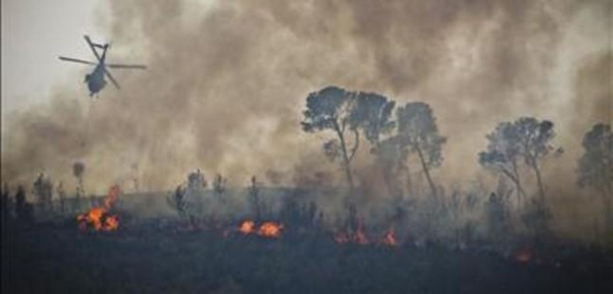 Un helicóptero derrama agua sobre el incendio de Andilla. Un helicóptero derrama agua sobre el incendio de Andilla.