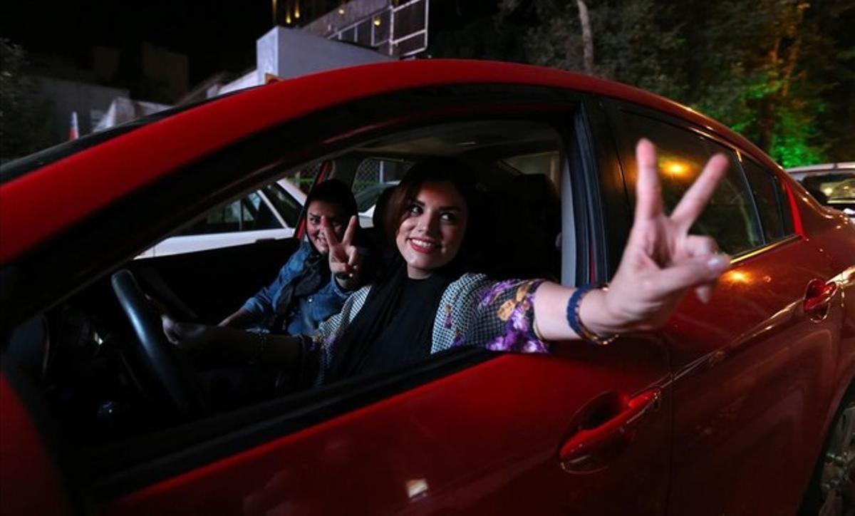 Una mujer iraní hace el signo de victoria desde un coche mientras circula por las calles de Teherán, el 14 de julio del 2015. La mujer se muestra contenta tras la consecución de un acuerdo nuclear en Irán.