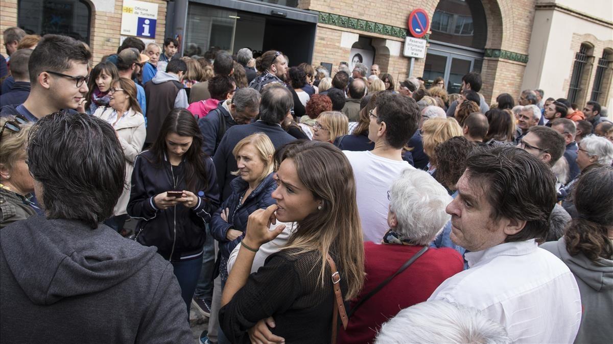 Ciudadanos esperando pacientemente la resolución de los problemas informáticos en Figueres.
