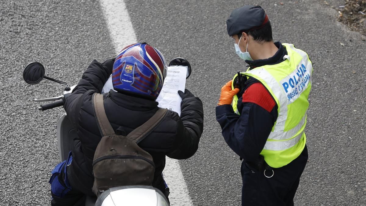 Un motorista muestra a un agente un justificante en un control de los Mossos en la Gran Via de Barcelona, junto a la Ciutat de la Justícia, el 7 de abril del año pasado. Un motorista muestra a un agente un justificante en un control de los Mossos en la Gran Via de Barcelona, junto a la Ciutat de la Justícia, el 7 de abril del año pasado.