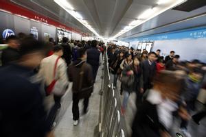 Gente en un túnel en el metro de Pekín.