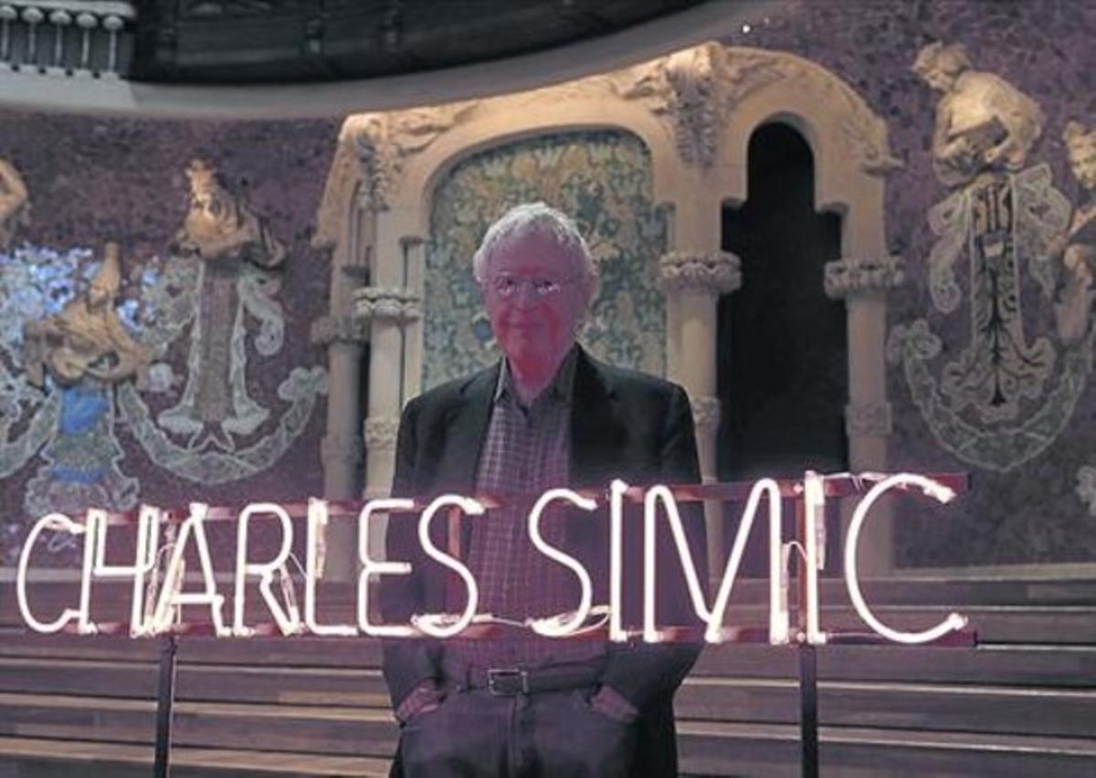 Charles Simic, tras a un letrero luminoso con su nombre en el Palau de la Música Catalana.